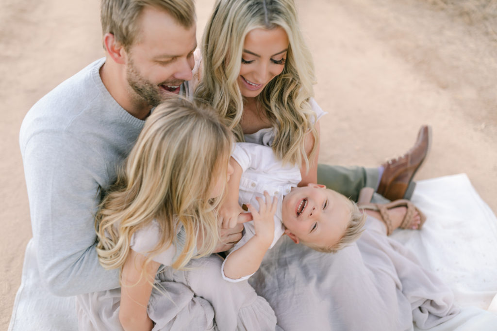 Katelyn Jones A Touch of Pink Blog Family Photoshoot with Reshma Photography in Southern California Orange County. The mother Katelyn and the father Alex are smiling for photo with son Dane and daughter Kennedy.